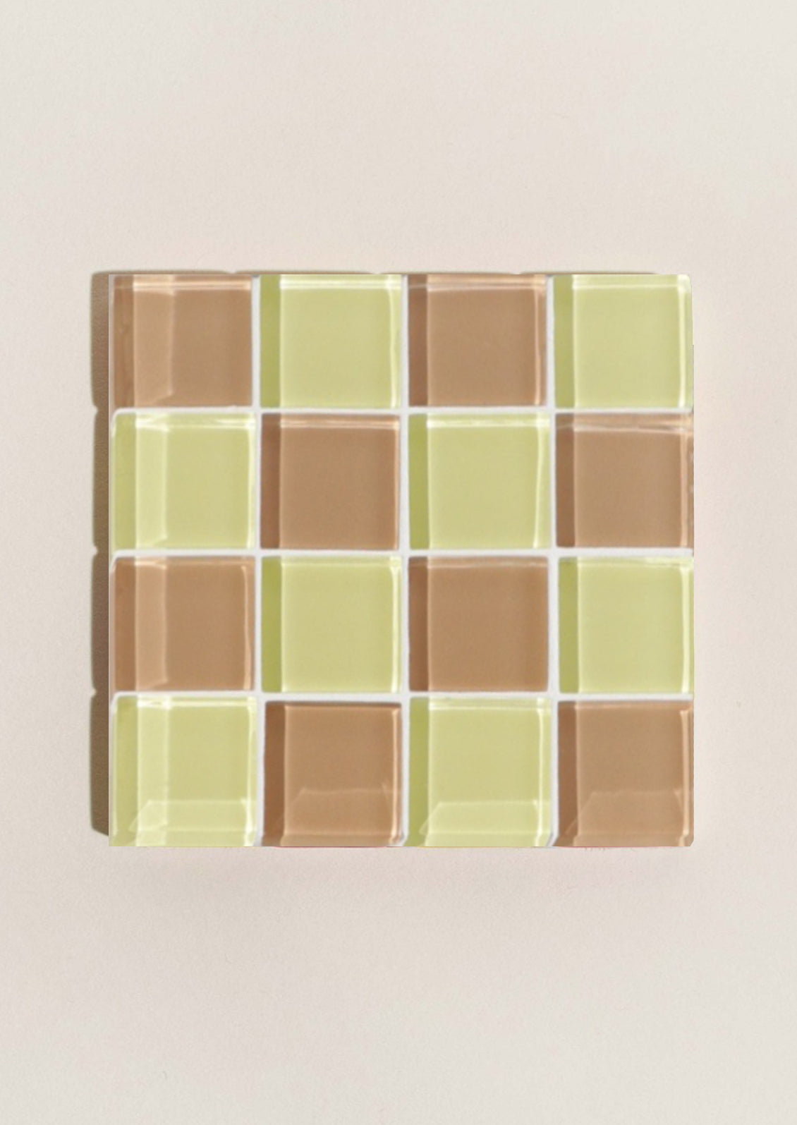 A glass tile coaster in two tone checker pattern in citron yellow and chocolate brown.