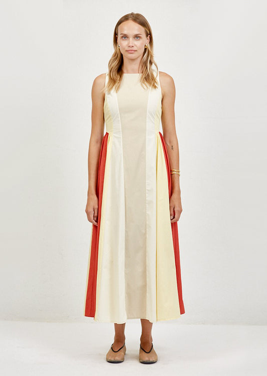 Woman wearing a sleeveless dress with red and yellow stripes on a white background