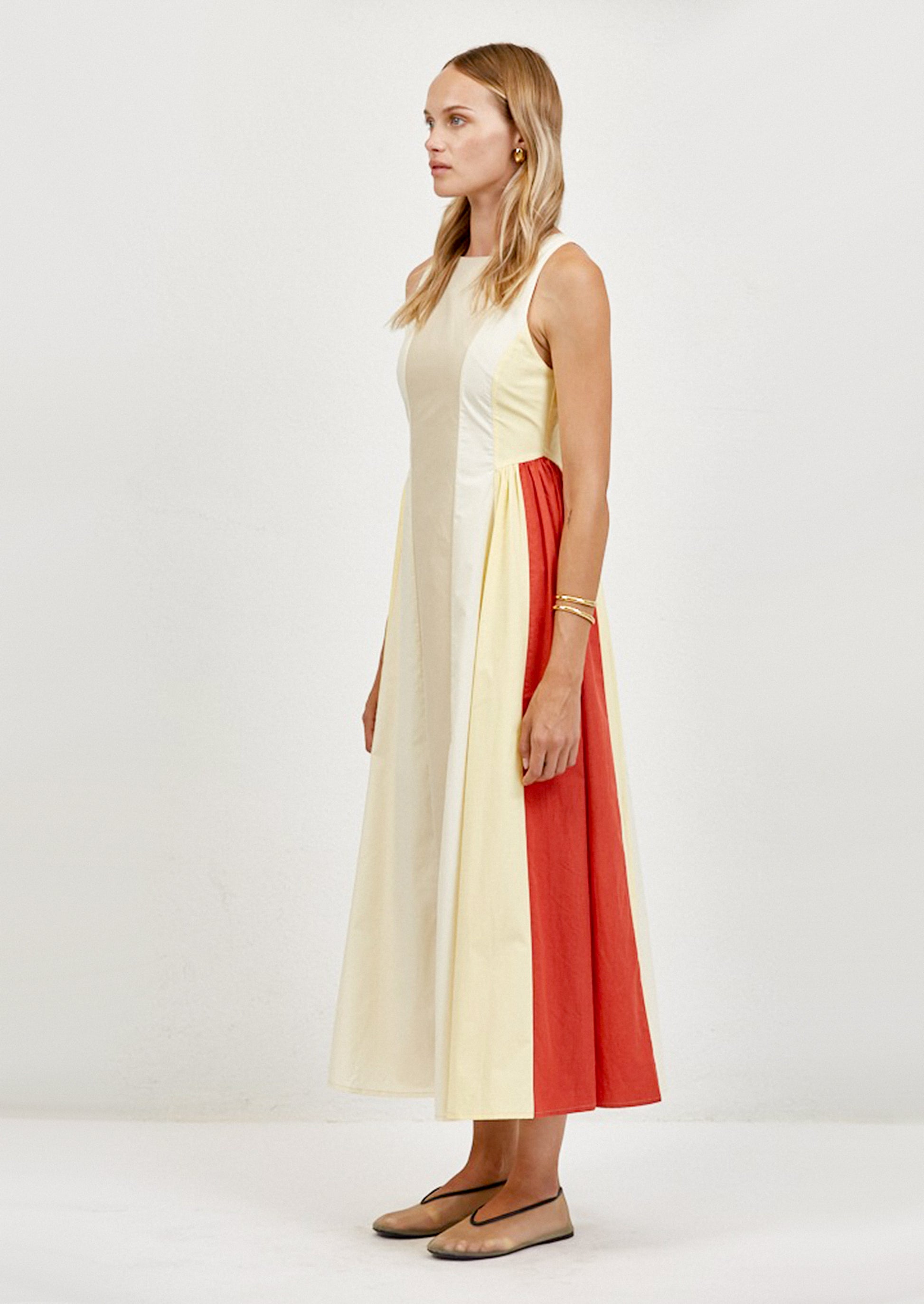Woman wearing a sleeveless dress with a color-block design on a white background