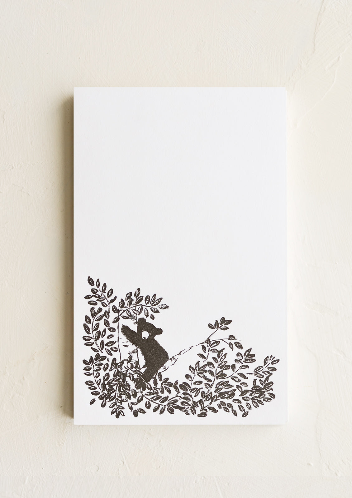 A letterpress printed notepad with panda design at bottom.
