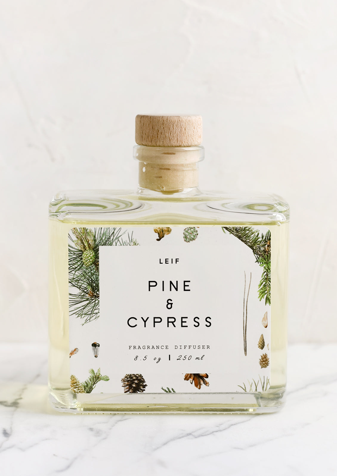 A pine and cypress scented reed diffuser with glass bottle.