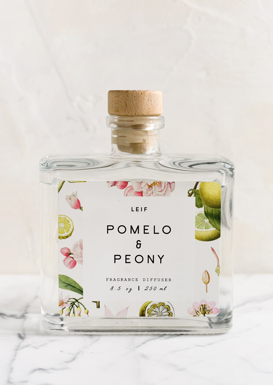 A pomelo and peony scented reed diffuser with glass bottle.