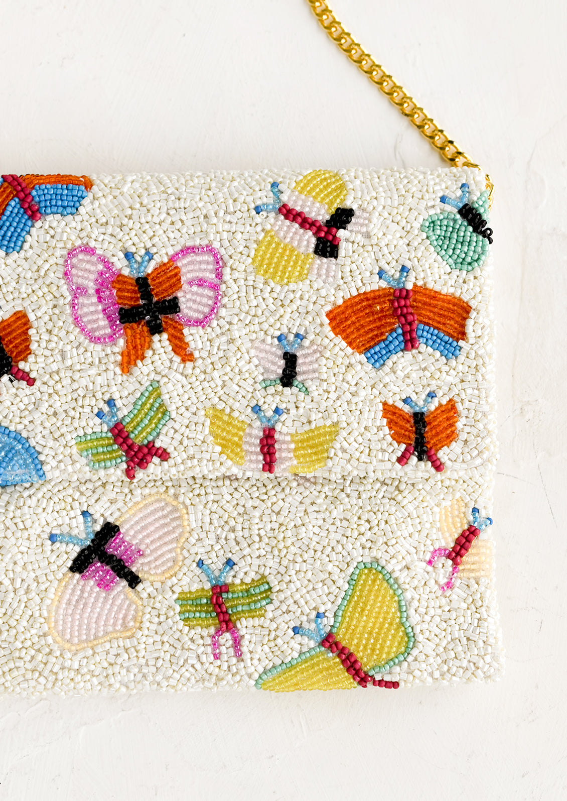 A butterfly beaded clutch with gold chain shoulder strap.
