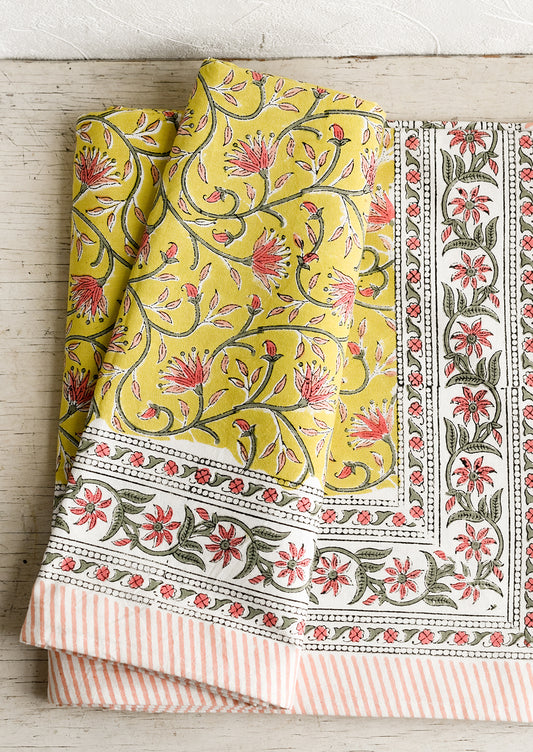 A block printed tablecloth in yellow, pink and green floral.