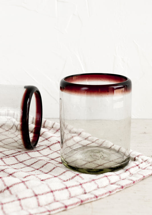 A heavy rocks glass in natural glass with purple rim around top.