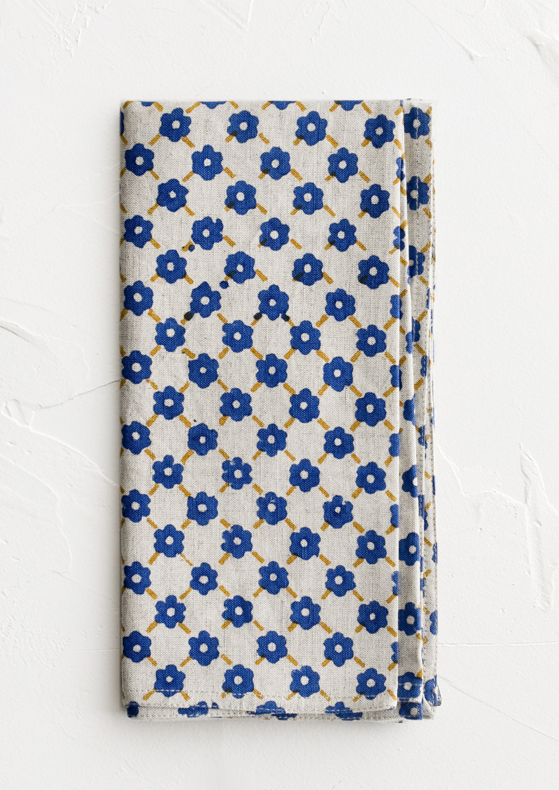 A block printed napkin with blue and yellow floral print.