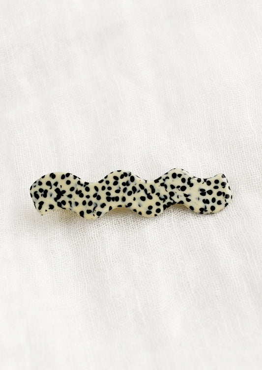 A wavy hair barrette in black and white spot print.
