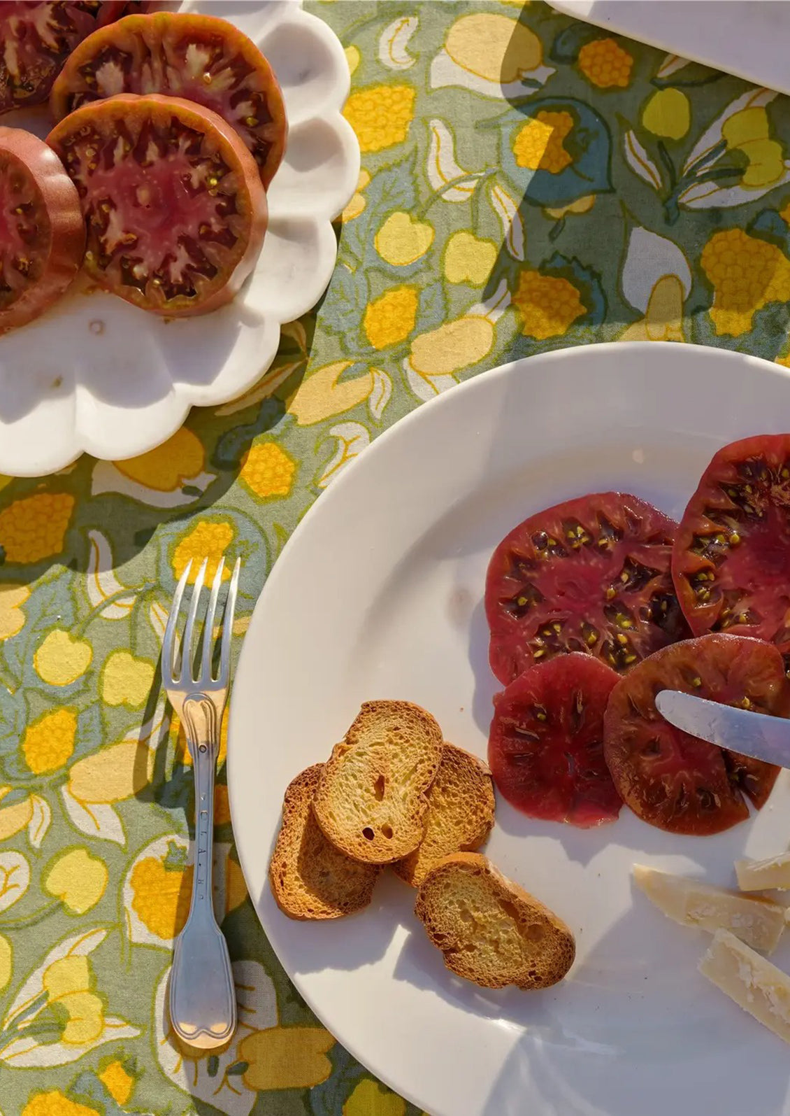 A table setting with green and yellow tablecloth.