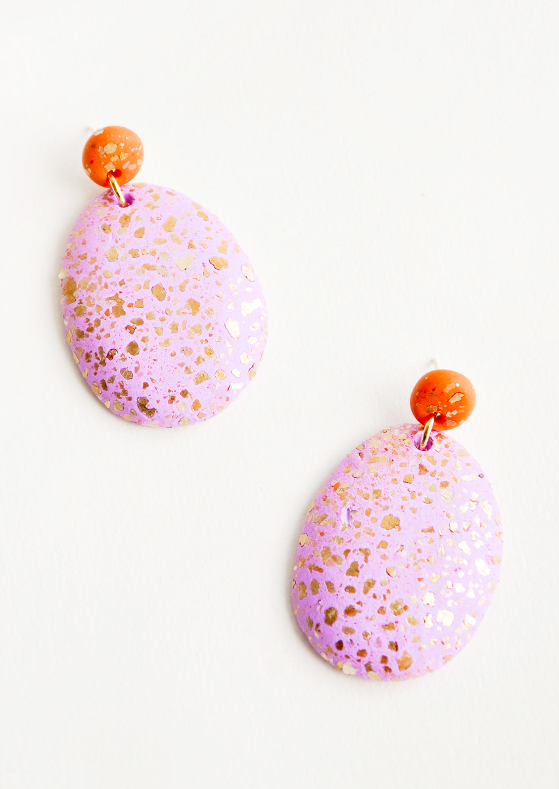 Dangling glitter covered earrings, with a pink larger oval dangling from a small red bead.