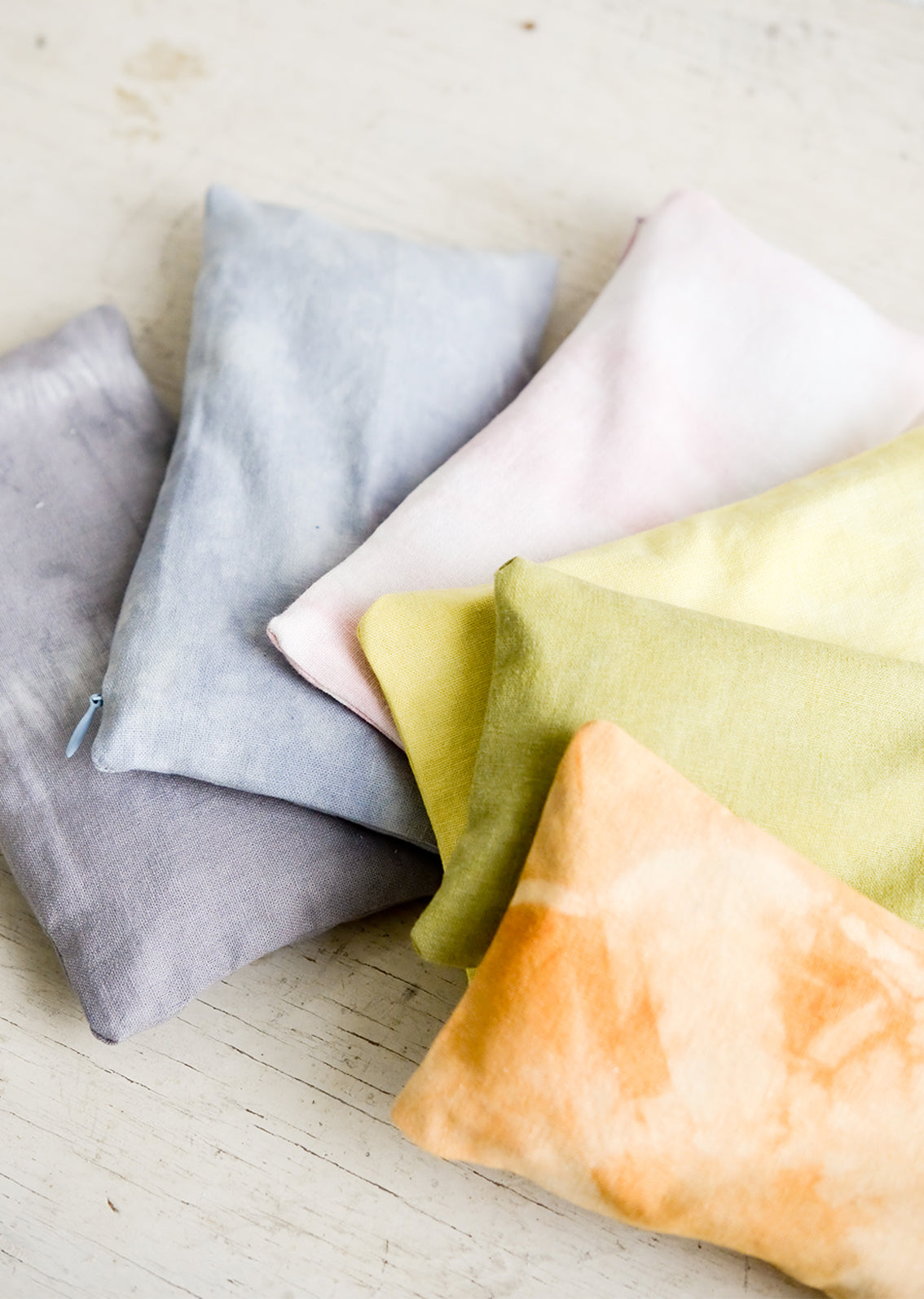 An assortment of relaxation eye pillows in a naturally dyed, rainbow span of colors.