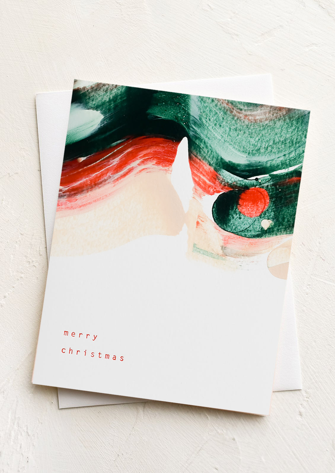 A greeting card with red and green paintswirl and text at corner reads "merry christimas".