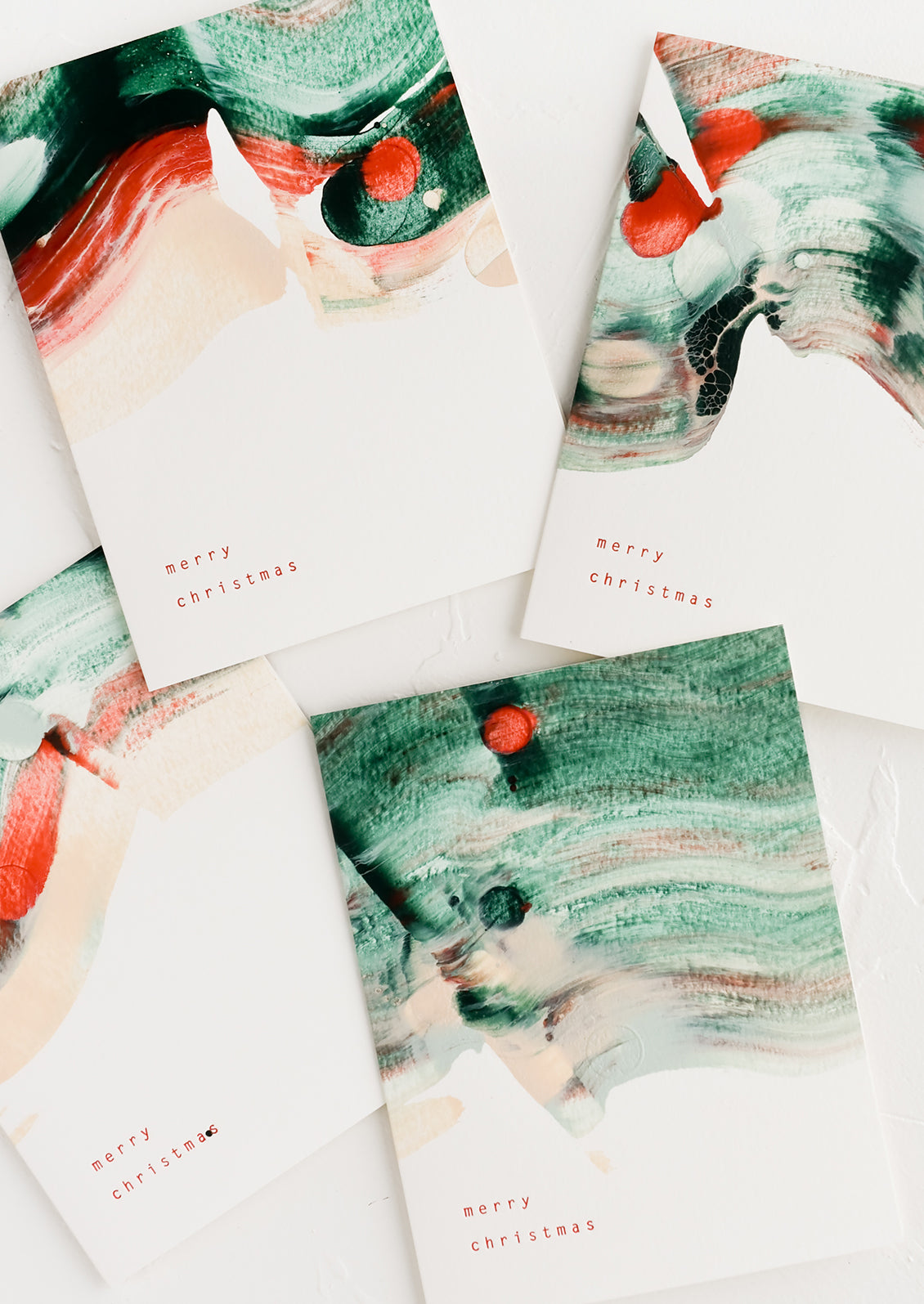 A greeting card with red and green paintswirl and text at corner reads "merry christimas".