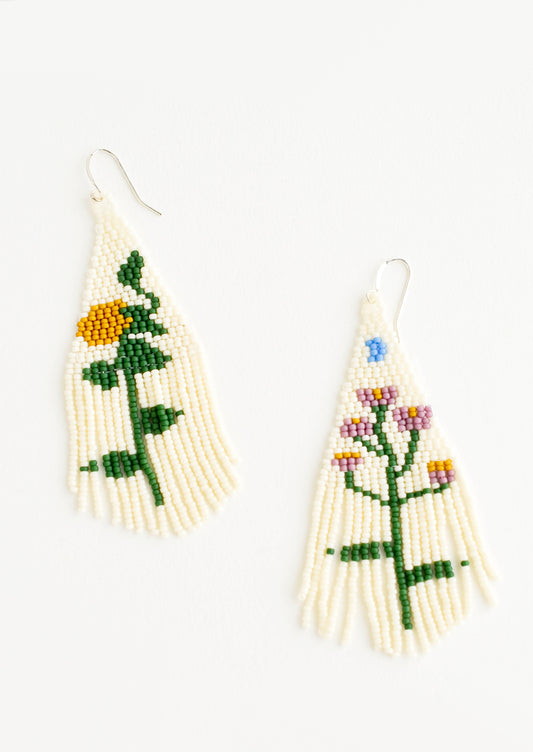 Cream colored beaded fringe earrings each depicting a different flower.
