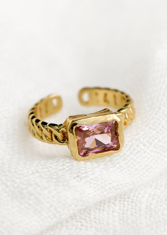 A gemstone ring with heavy chainlink band and rectangular pink baguette.