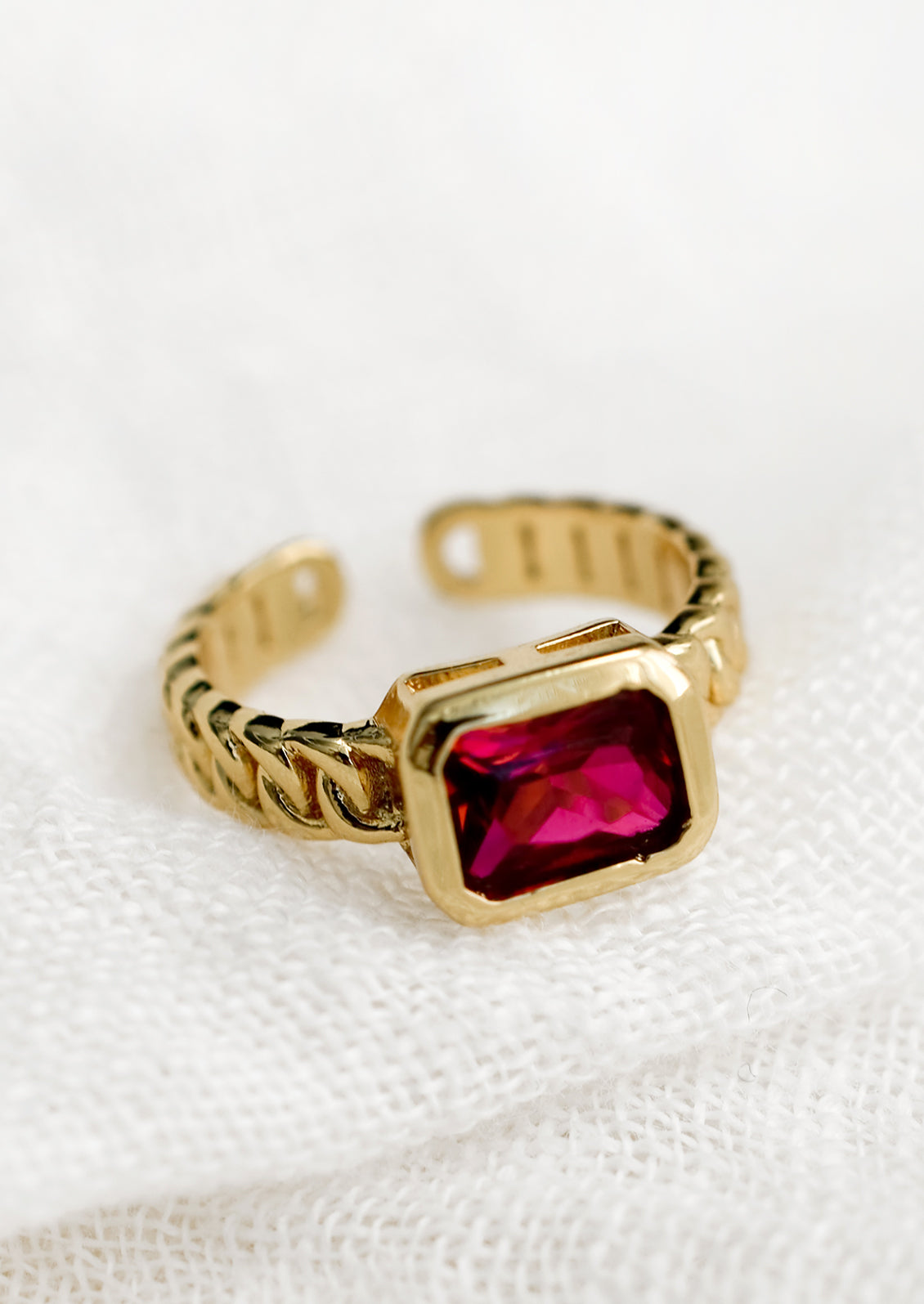 A gemstone ring with heavy chainlink band and rectangular ruby baguette.