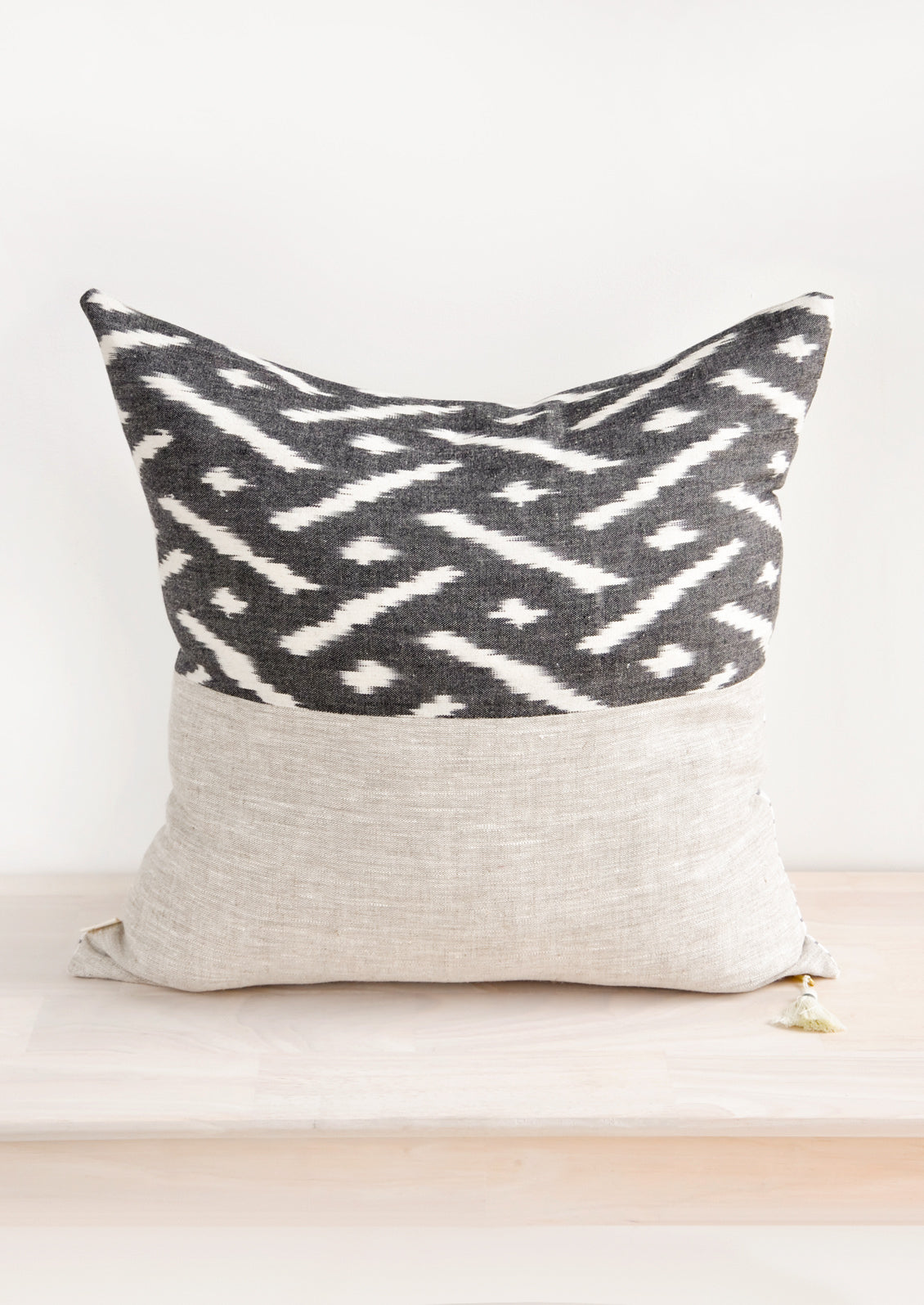 Square throw pillow in reversible design with contrasting black and white fabric on front and back