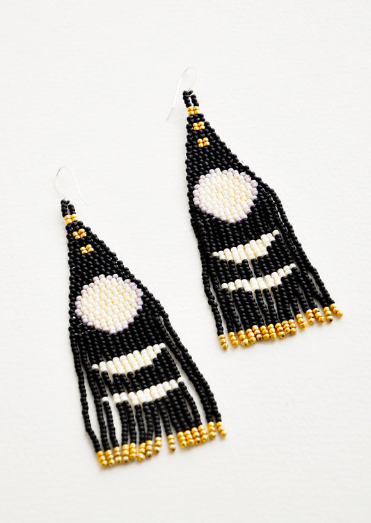 Dangling earrings with black and white geometric beaded shapes and black and gold beaded fringe.