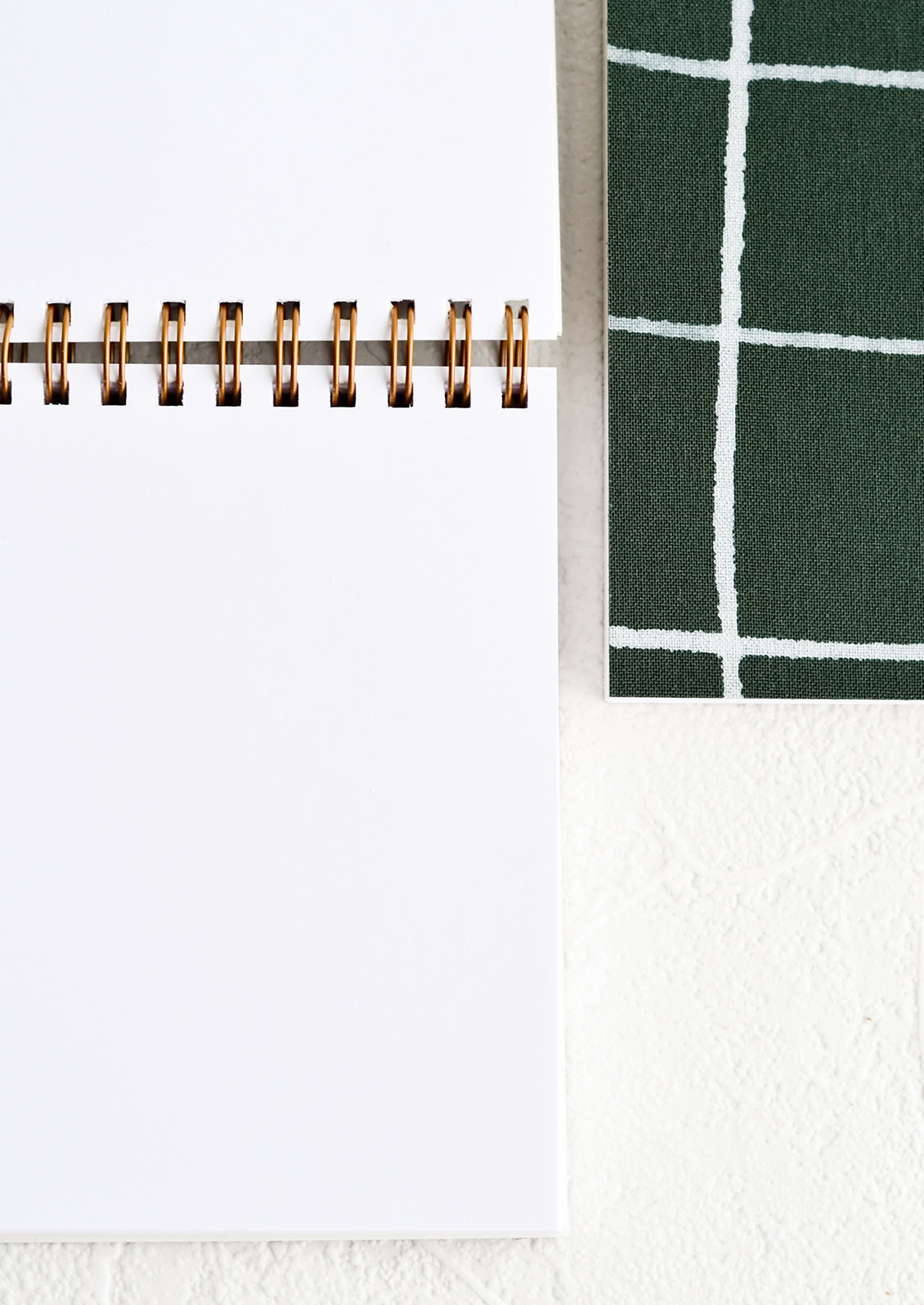 A small spiral bound notebook with blank unlined pages.