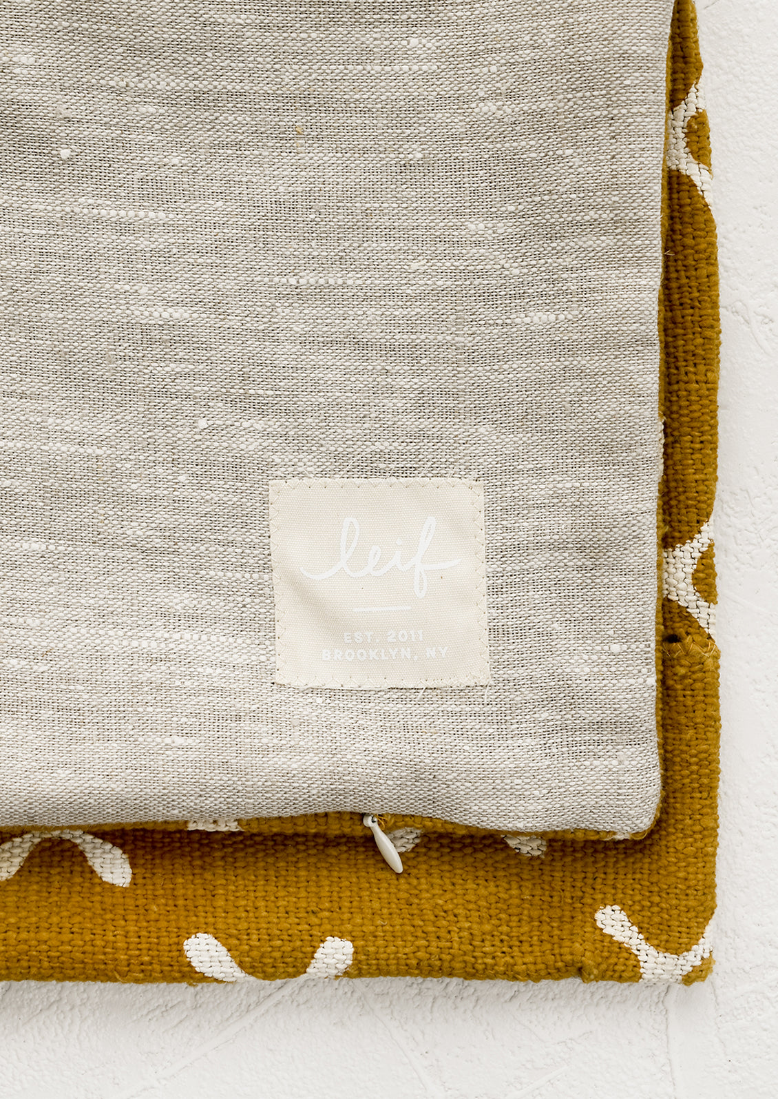 Natural linen pillow backing with logo patch.