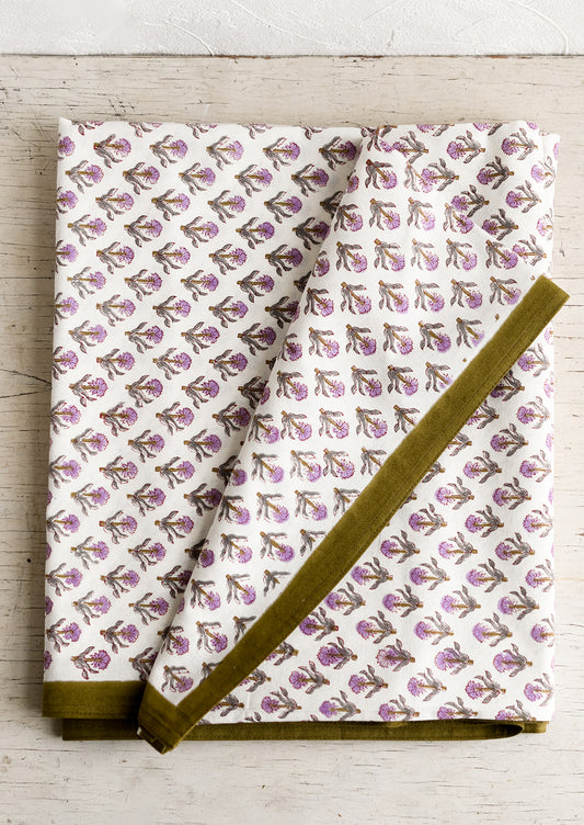 A purple and olive green floral print tablecloth.