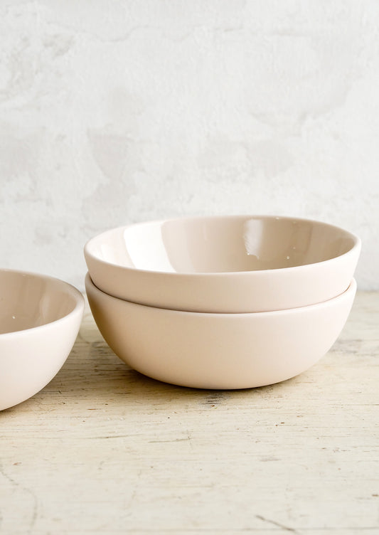 Matte porcelain bowls in nude hue with glossy interior.