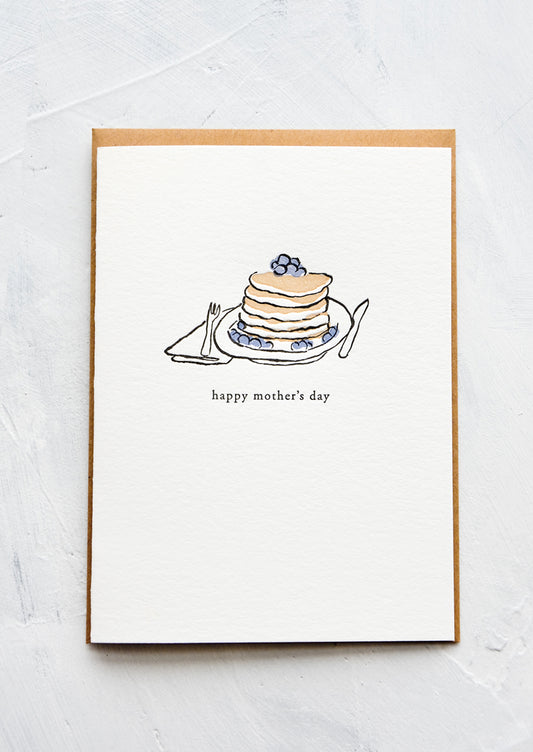 A letterpress printed greeting card with an image of blueberry pancakes stacked on a plate. Text below image reads "happy mother's day".