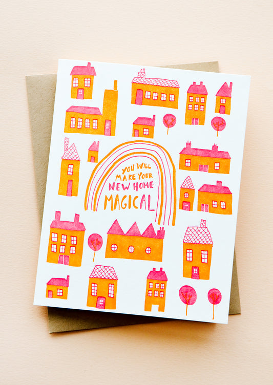 Greeting card with pink and orange houses, text at center reads "You Will Make Your New Home Magical".