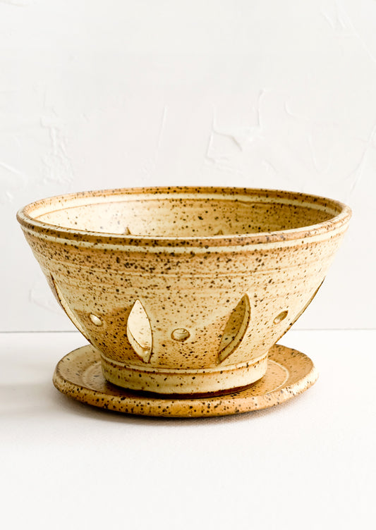 A ceramic berry bowl with plate in yellow speckle.