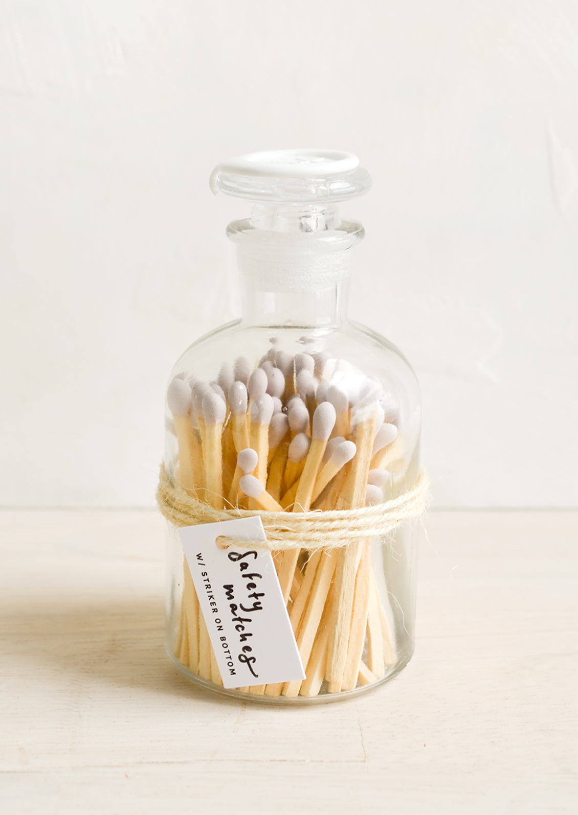 Safety matches with lavender tips in a vintage-style glass apothecary jar with white wax seal on lid.