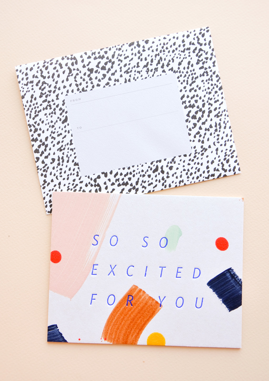 Notecard with colorful abstract shapes and the text "So So Excited For You", with spotted black and white envelope