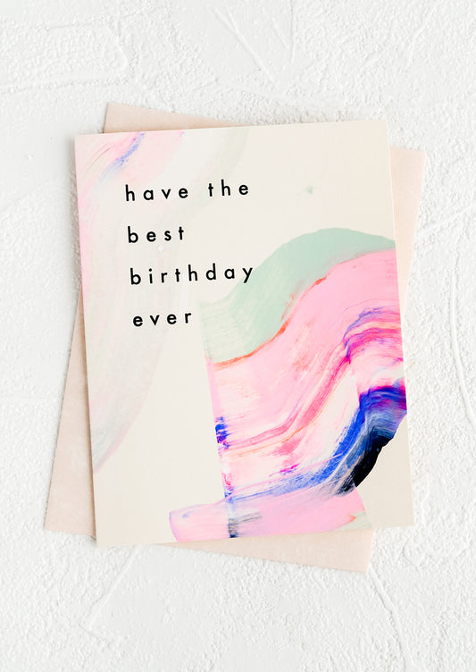 A greeting card with hand-painted streak of paint and black lettering reading "Have the best birthday ever"