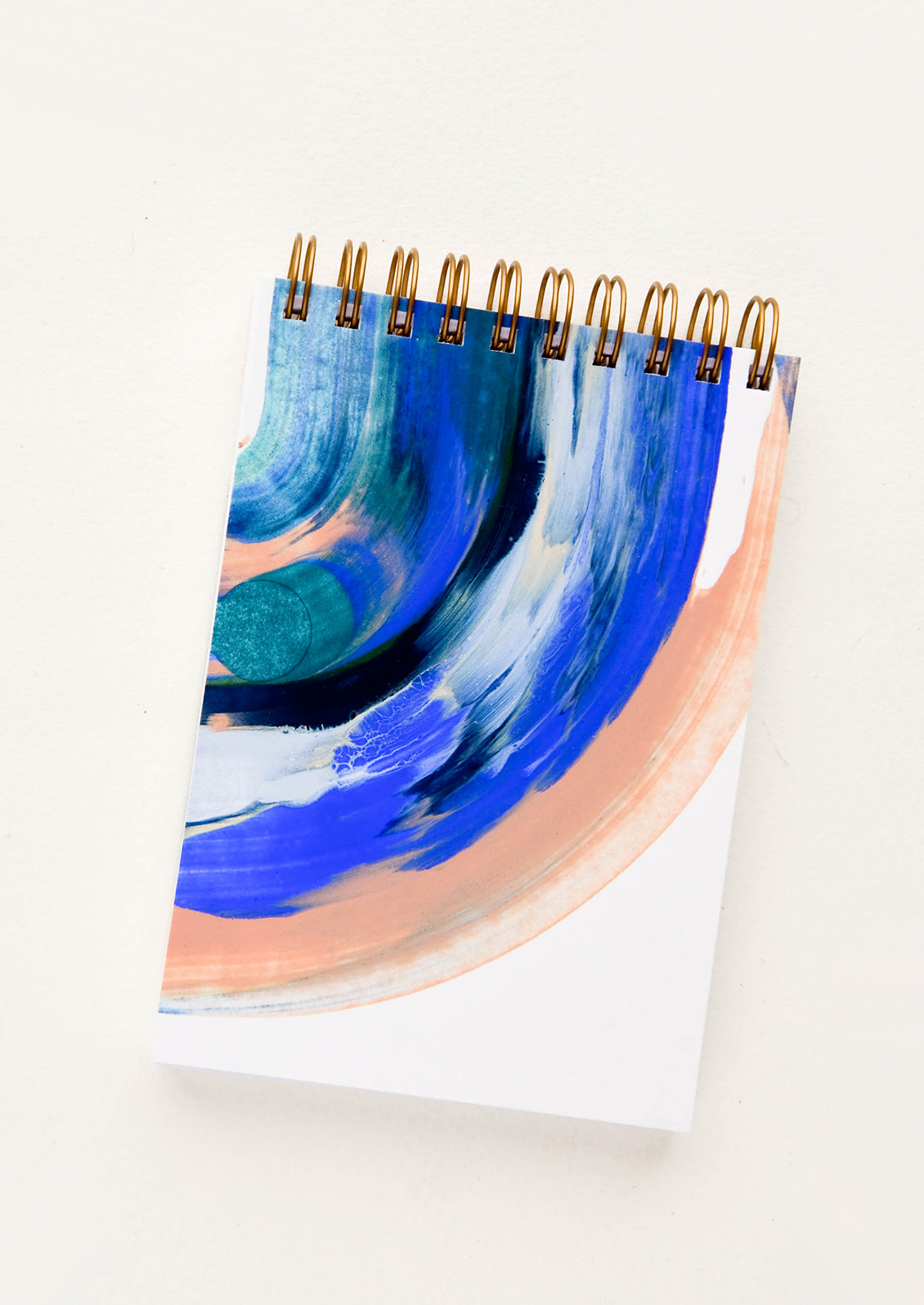 Pocket-size spiral bound notebook with handpainted cover in blue and peach paint swirl