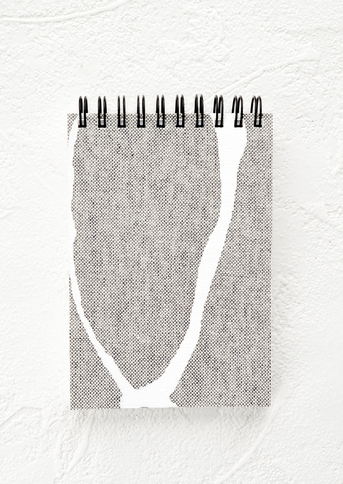 A small spiral bound pocket notebook with grey and white cover.
