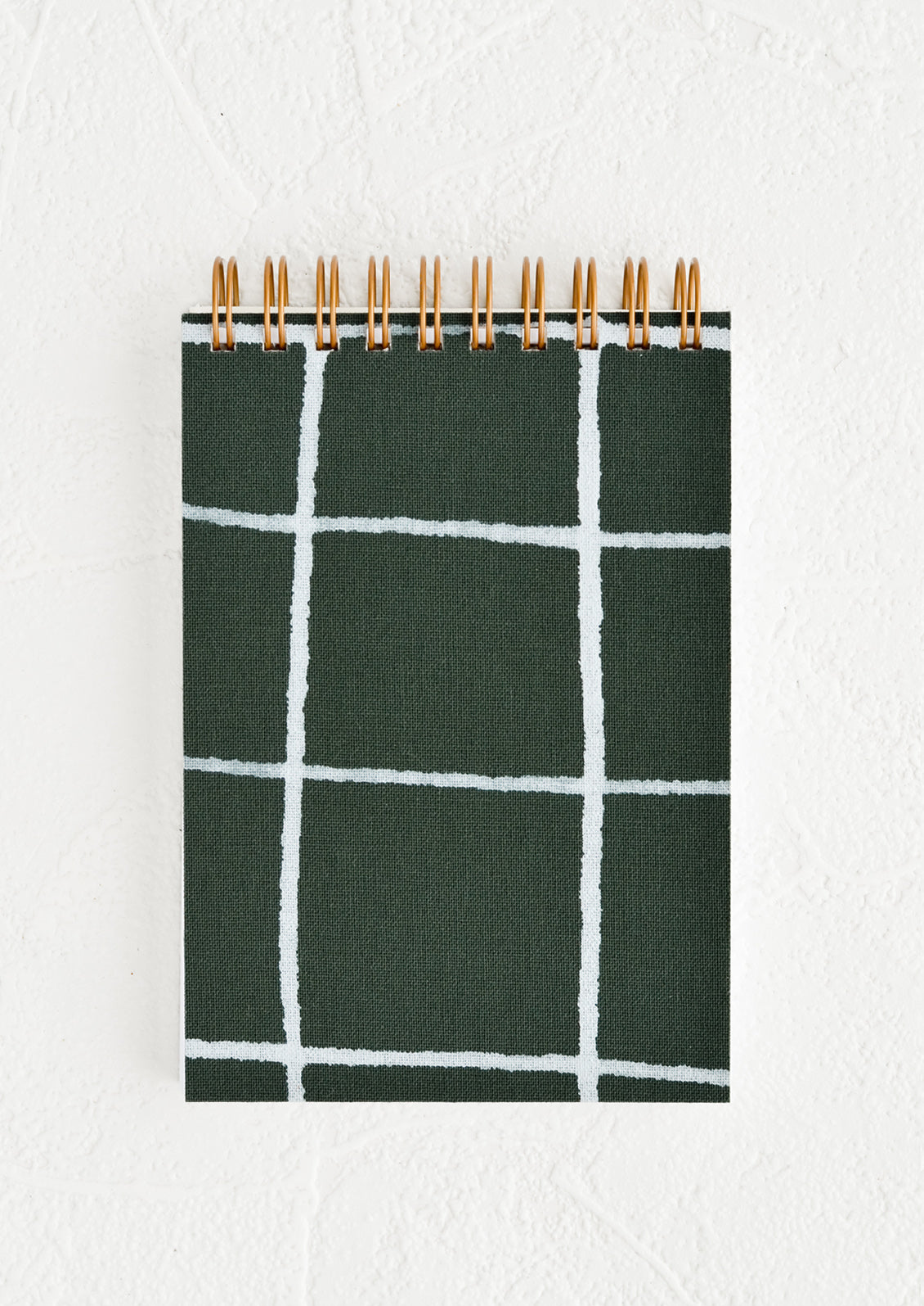 A small spiral bound pocket notebook with dark green and white cover.