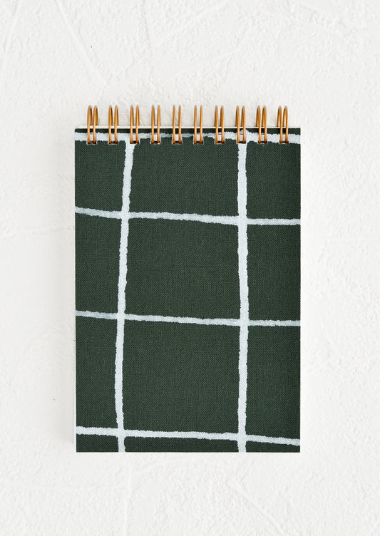 A small spiral bound pocket notebook with dark green and white cover.