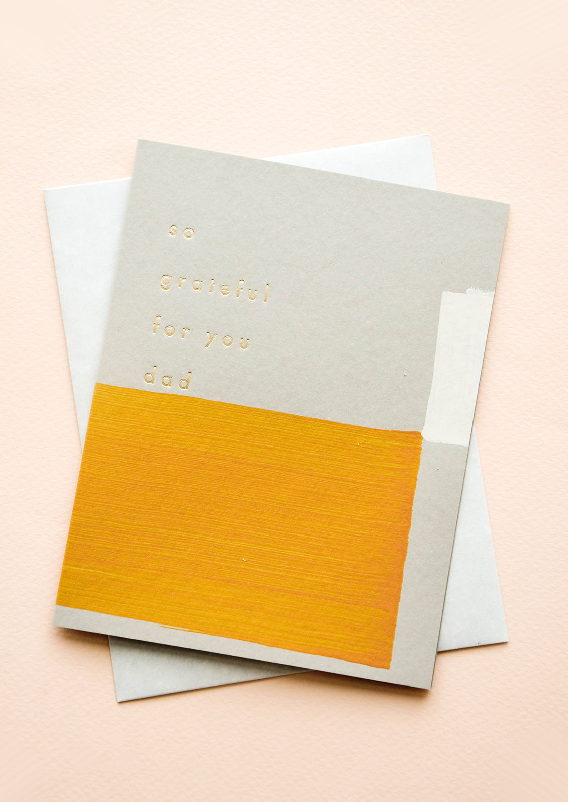 Greeting card with hand-painted square shapes in mustard and white, gold text reads "So grateful for you dad"