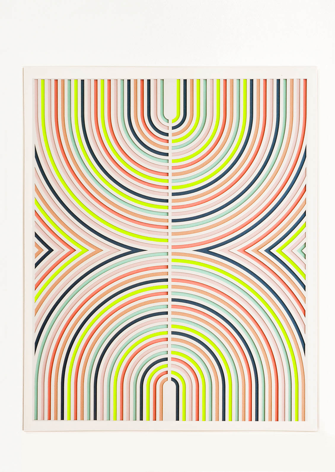 Lasercut artwork featuring mirrored half-arcs in a neon color palette