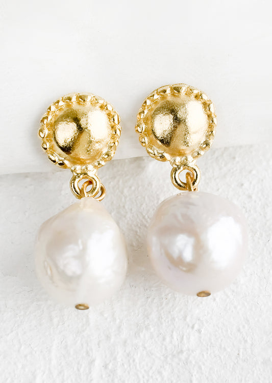 A pair of pearl & gold earrings with circular post and round pearl.