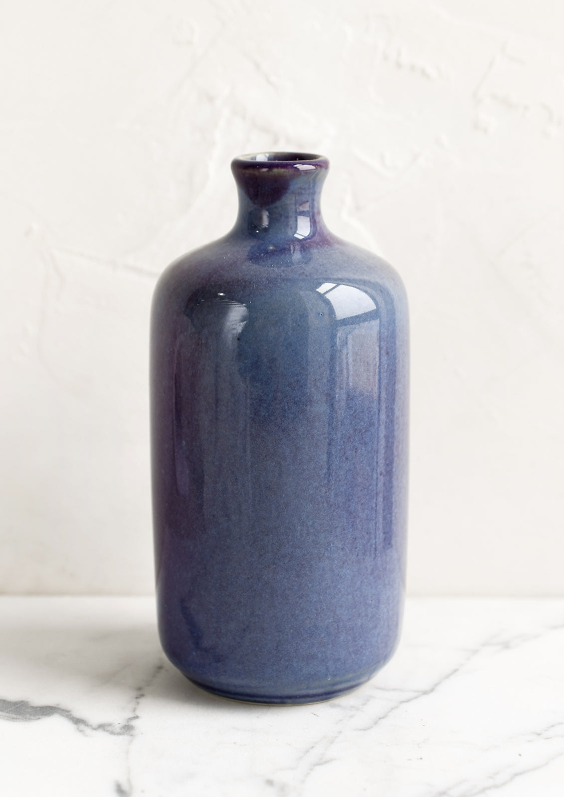 A ceramic bud vase in tall shape, blueberry color.