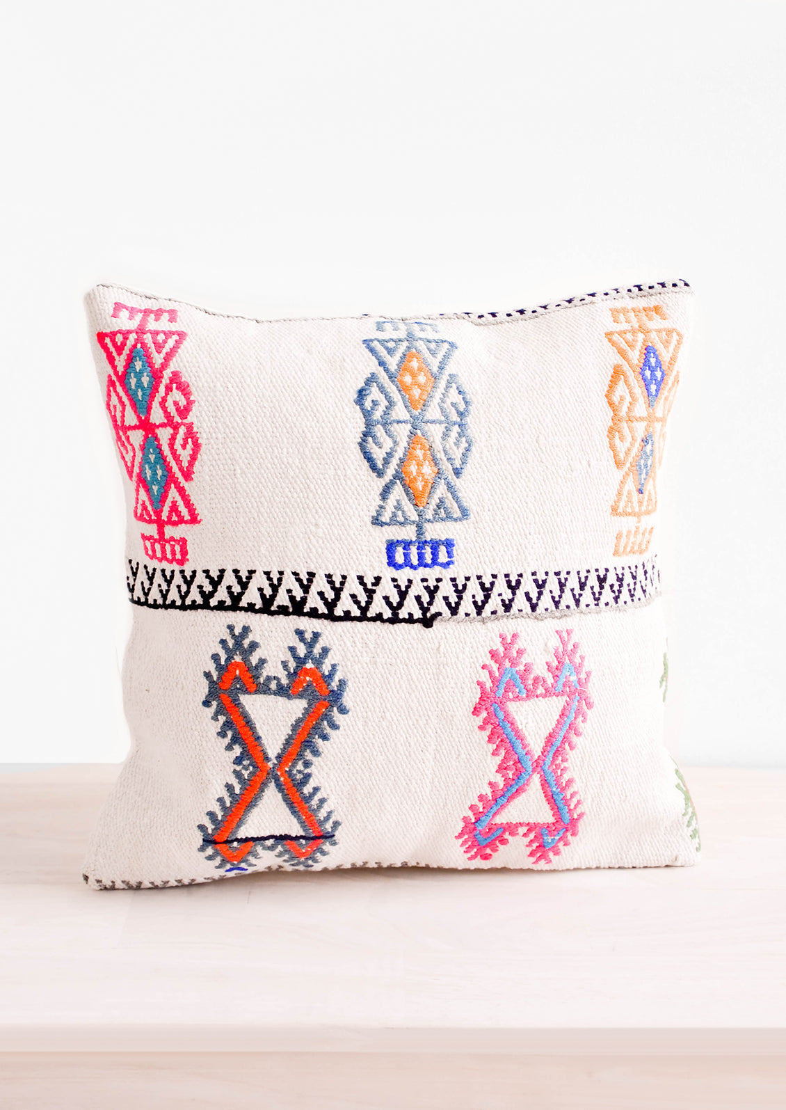 Square throw pillow with neon embroidery on ivory background