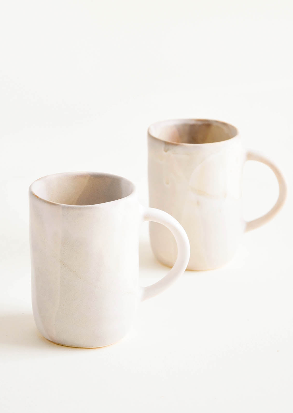 Ceramic mugs with handle, shown in matte watercolor glaze.