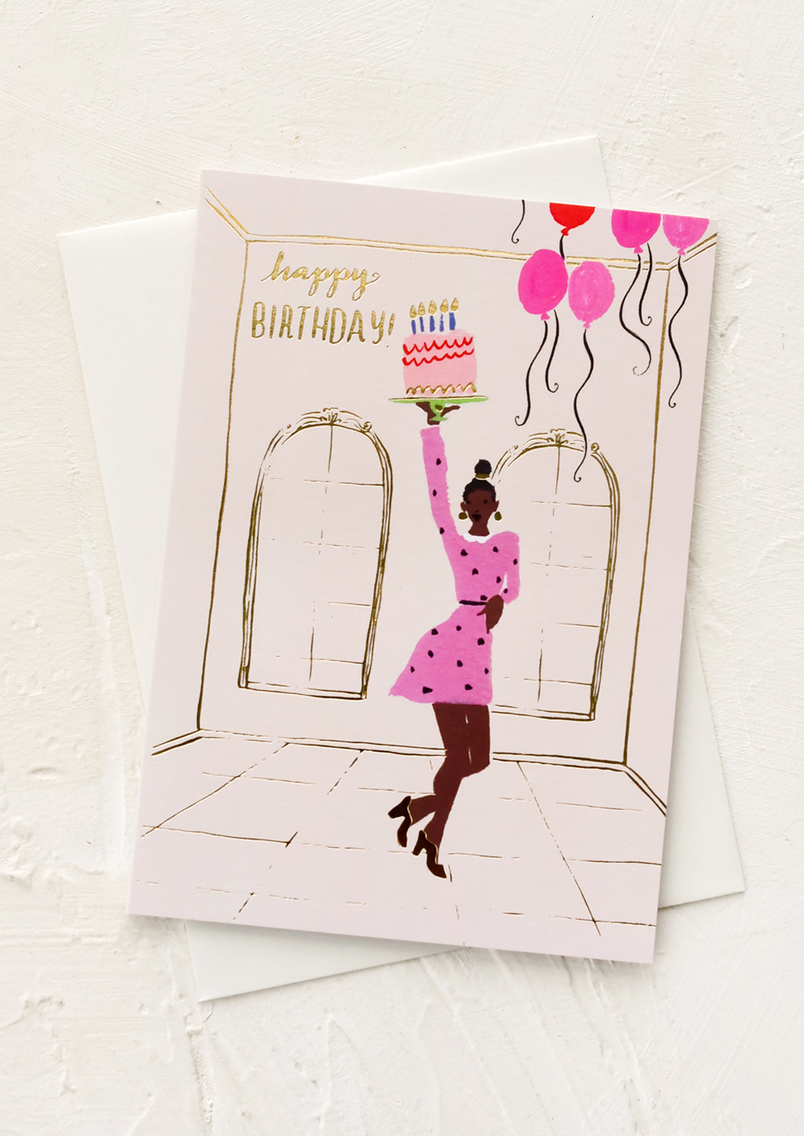 A greeting card with illustration of a black woman in a party dress holding a birthday cake.