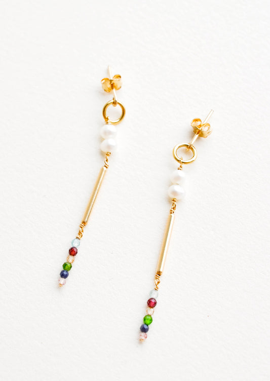 Dangling earrings featuring a small circle, two pearl beads, a gold post and six small multicolor gemstones on a yellow gold post back.