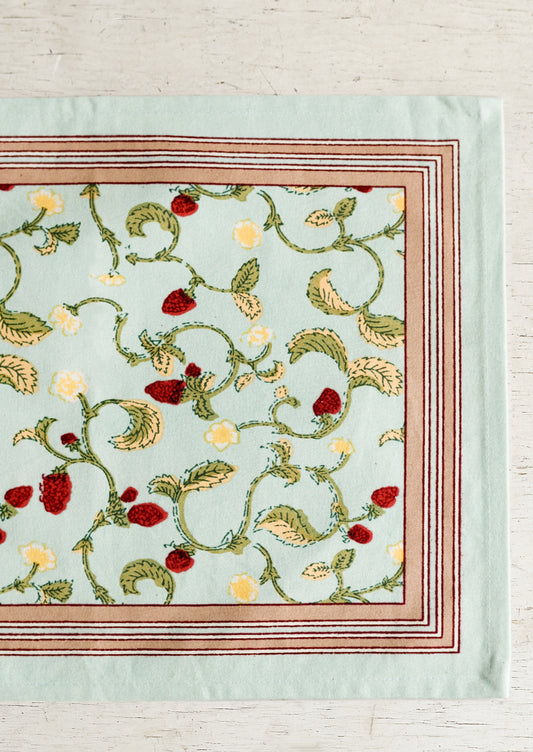 A light aqua placemat with bordered raspberry print.
