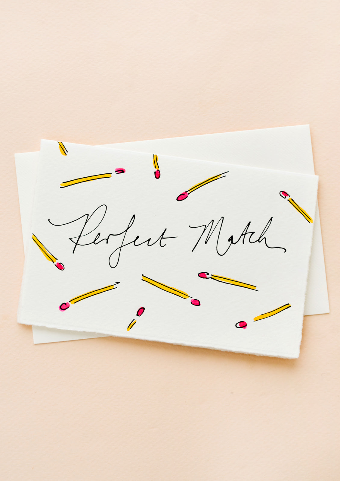 A white greeting card with hand-painted match sticks and "Perfect Match" written in cursive.