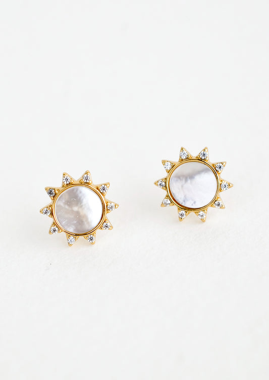 A pair of gold stud earrings in the shape of a sun with shell inlay center and crystal "sunray" border.