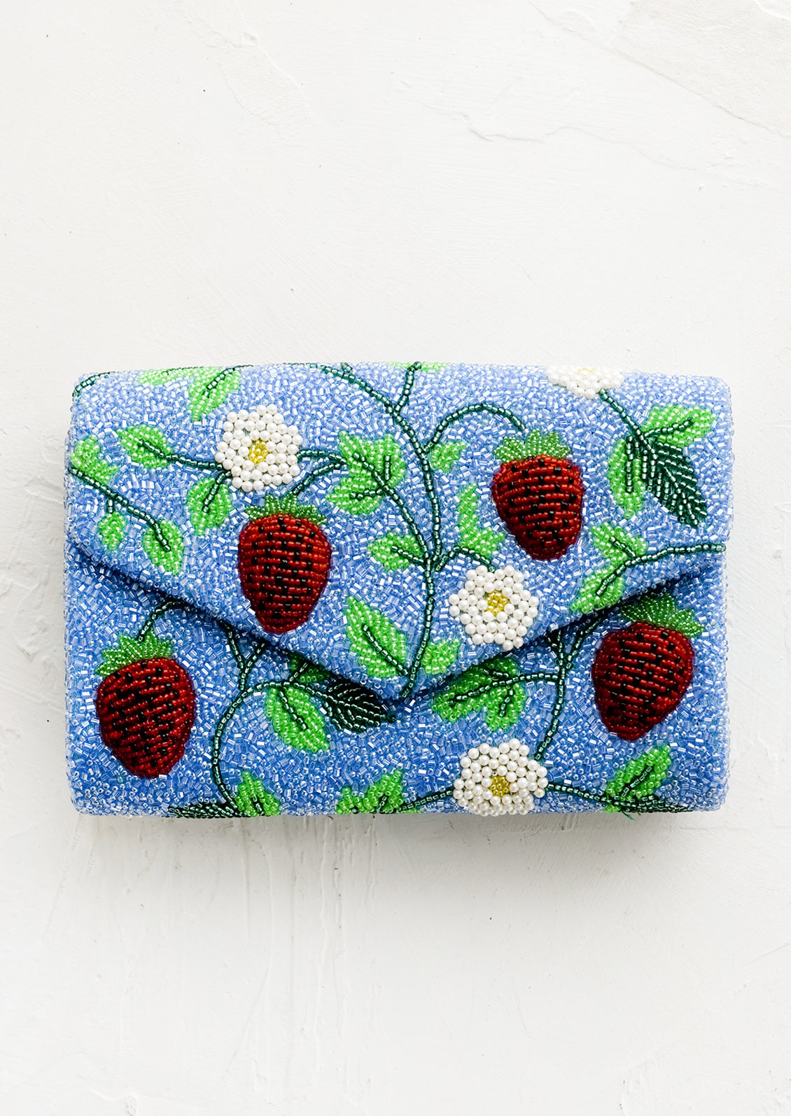 A blue beaded clutch with red strawberry pattern.
