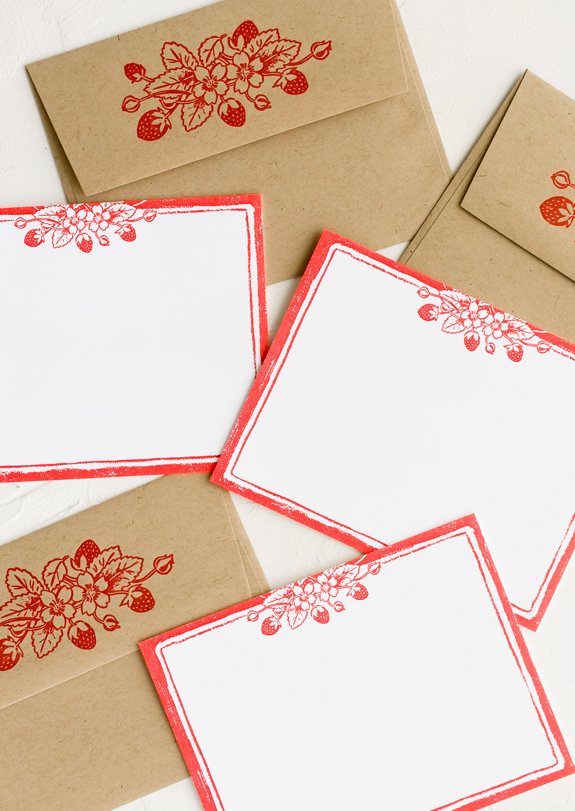A  set of white flat notecards with strawberry print border.