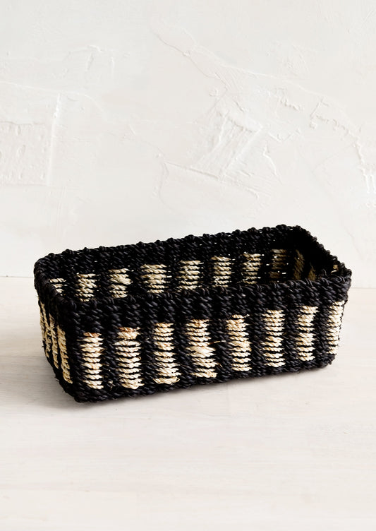 A structured rectangular storage basket in black with tan dashes.