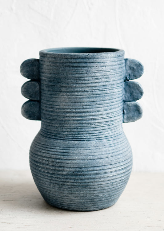 An ocean blue ceramic vase with etched ribbing and side tabs.